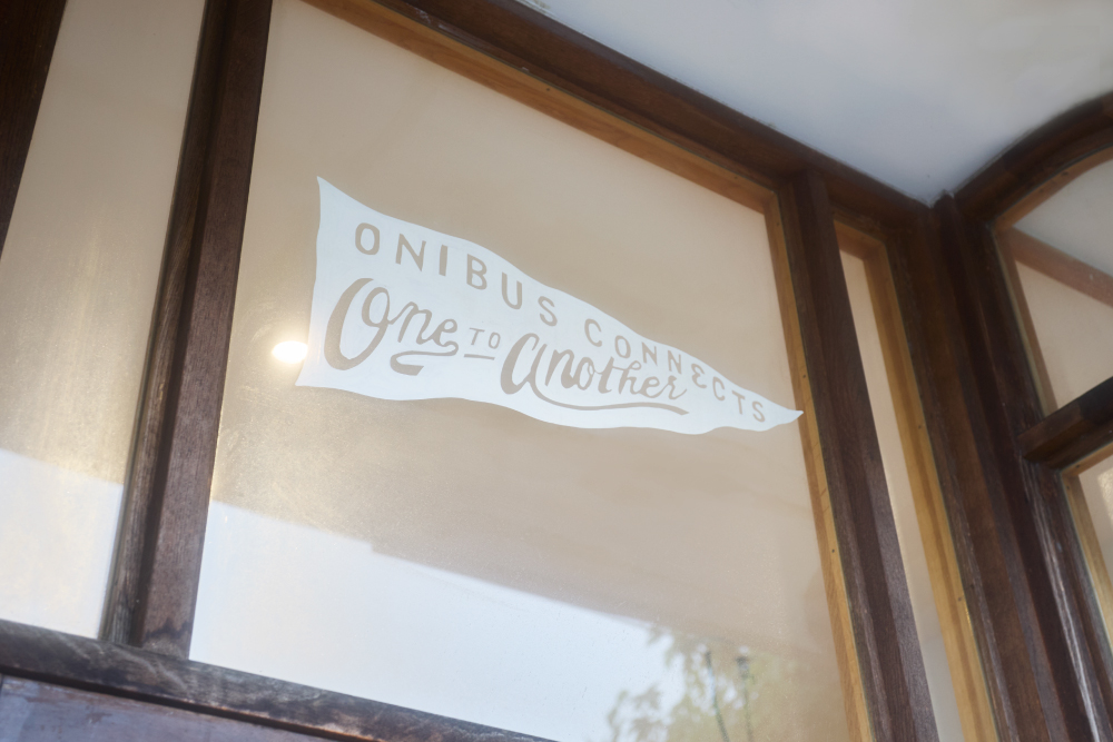店舗外観に描かれている旗のイラスト「ONIBUS CONNECTS one TO another」と記載
