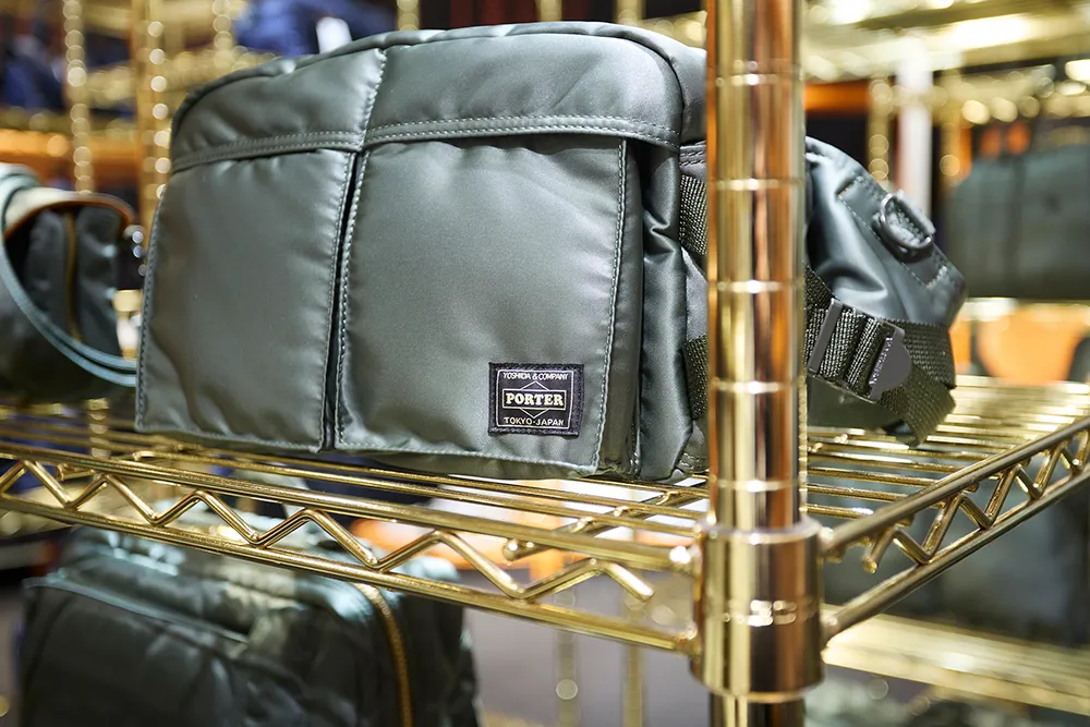 ゴールドのシェルフに展示されたPORTERのバッグ