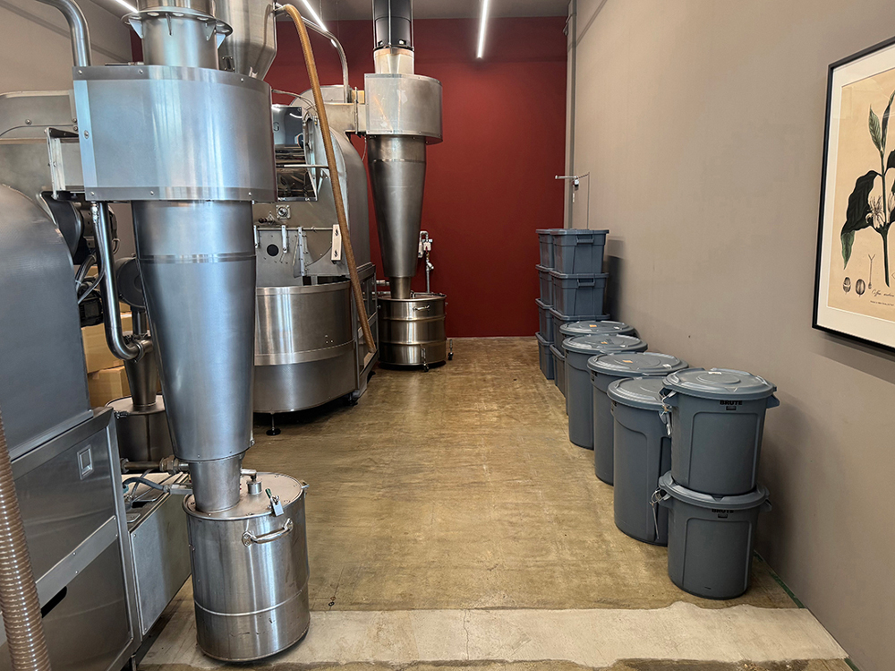 焙煎機の横に並ぶブルートコンテナ